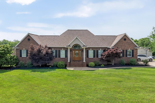103 Mohawk Trl, Dry Ridge, KY 41035 - view of front of home with a front lawn, a shingled roof, and brick siding