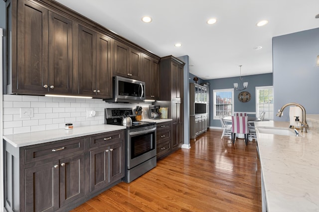 103 Mohawk Trl, Dry Ridge, KY 41035 - kitchen with appliances with stainless steel finishes, light wood-type flooring, dark brown cabinetry, backsplash, and recessed lighting