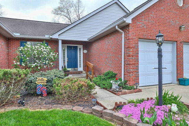 6315 Baymiller Ln, Burlington, KY 41005 - doorway to property featuring brick siding, a garage, roof with shingles, and driveway