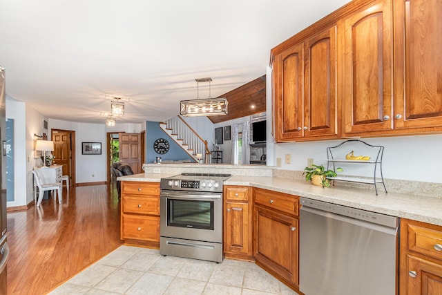 9500 Lower River Rd, Burlington, KY 41005 - kitchen featuring appliances with stainless steel finishes, brown cabinets, and a peninsula