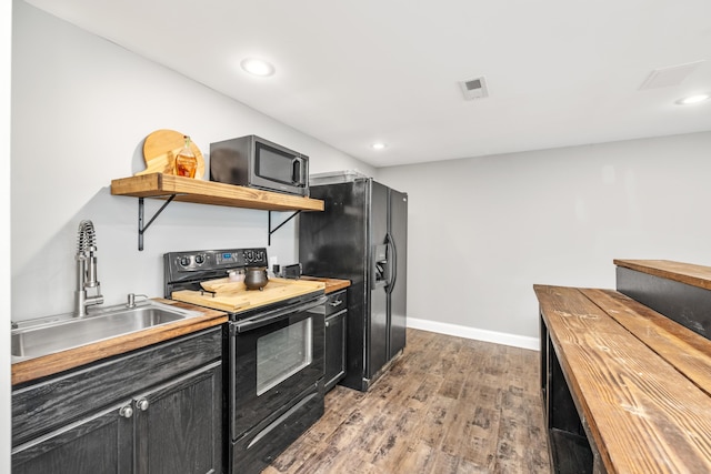 2373 Frontier Dr, Hebron, KY 41048 - kitchen with black appliances, open shelves, light wood-style flooring, dark cabinets, and butcher block counters