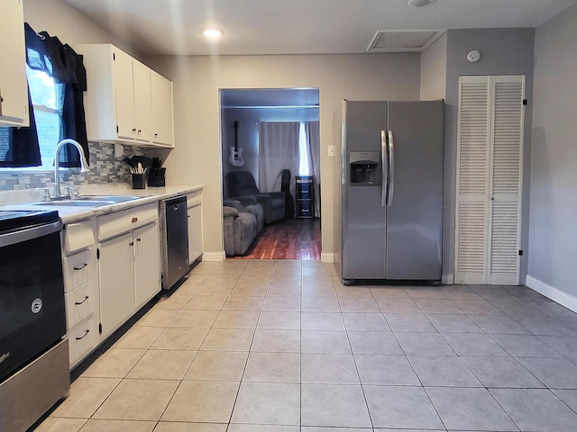 635 Willow St, Elsmere, KY 41018 - kitchen featuring stainless steel appliances, light countertops, light tile patterned floors, white cabinetry, and backsplash