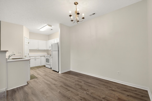 523 Ivy Ridge Dr, Cold Spring, KY 41076 - kitchen featuring white appliances, wood finished floors, a chandelier, white cabinets, and light countertops
