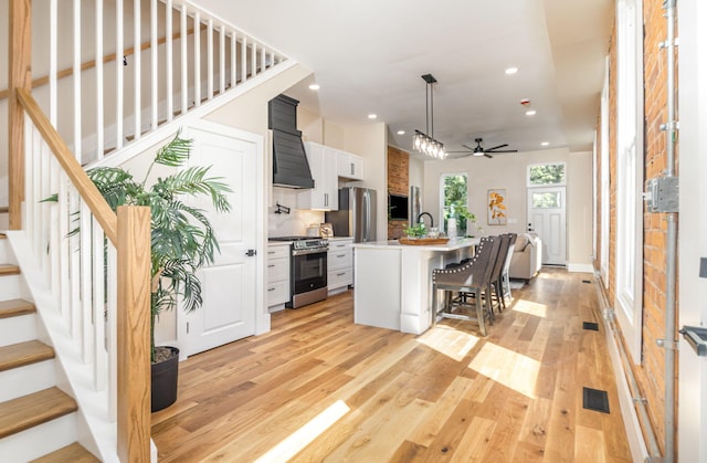 243 Latta Ave, Ludlow, KY 41016 - kitchen featuring stainless steel appliances, premium range hood, recessed lighting, a breakfast bar area, and light wood-style floors