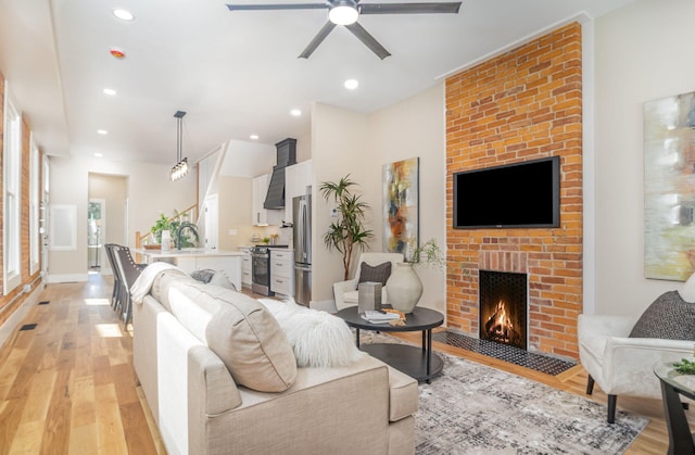 243 Latta Ave, Ludlow, KY 41016 - living room with light wood-style flooring, a ceiling fan, a fireplace, and recessed lighting