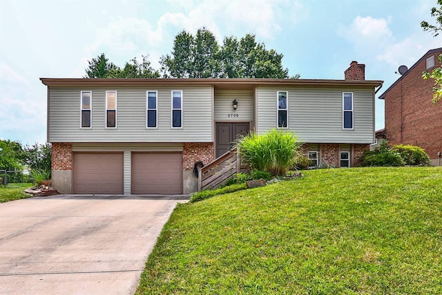 2709 Wesley Dr, Villa Hills, KY 41017 - bi-level home featuring brick siding, a front yard, a garage, a chimney, and concrete driveway
