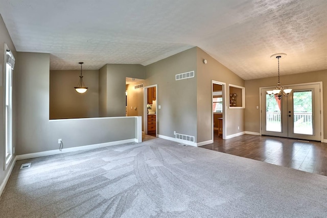 2709 Wesley Dr, Villa Hills, KY 41017 - spare room featuring dark colored carpet, lofted ceiling, a chandelier, a textured ceiling, and french doors