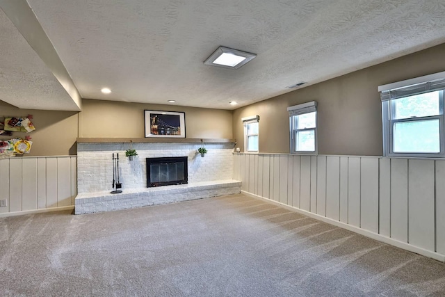2709 Wesley Dr, Villa Hills, KY 41017 - unfurnished living room featuring carpet, a textured ceiling, a brick fireplace, wainscoting, and recessed lighting