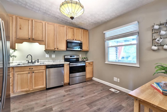 2709 Wesley Dr, Villa Hills, KY 41017 - kitchen featuring appliances with stainless steel finishes, light wood-type flooring, a textured ceiling, light brown cabinets, and lofted ceiling