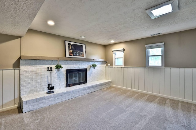 2709 Wesley Dr, Villa Hills, KY 41017 - unfurnished living room featuring a textured ceiling, a wainscoted wall, carpet floors, a brick fireplace, and recessed lighting