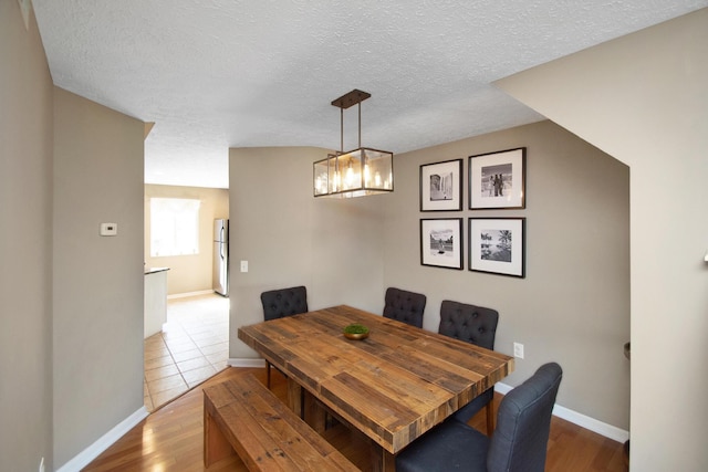 22 Carriage House Dr, Fort Thomas, KY 41075 - dining space featuring wood finished floors, a textured ceiling, and a chandelier