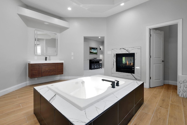 1025 Hyperion Ct, Union, KY 41091 - full bath featuring wood finished floors, a garden tub, vanity, recessed lighting, and a fireplace