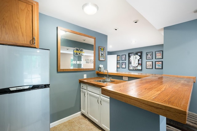 10234 Hempsteade Dr, Union, KY 41091 - kitchen featuring freestanding refrigerator, a peninsula, butcher block countertops, light tile patterned flooring, and recessed lighting