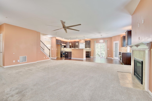 740 Norbie Dr, Burlington, KY 41005 - unfurnished living room featuring light colored carpet, a tile fireplace, ceiling fan, and stairway