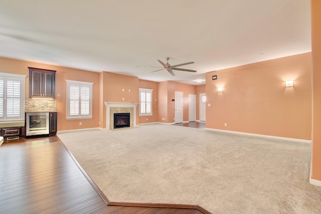740 Norbie Dr, Burlington, KY 41005 - unfurnished living room with a tiled fireplace, a ceiling fan, wood finished floors, wine cooler, and carpet