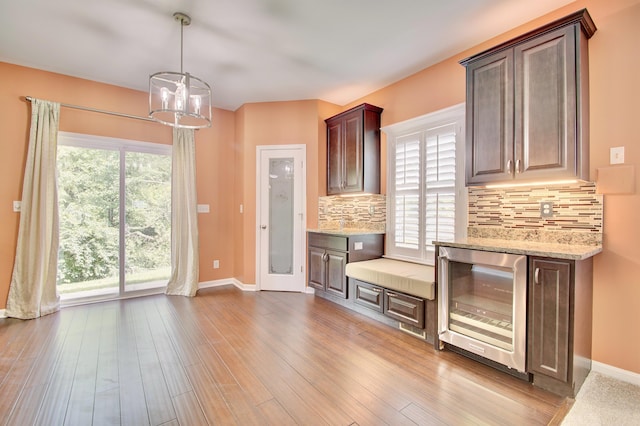 740 Norbie Dr, Burlington, KY 41005 - kitchen featuring beverage cooler, tasteful backsplash, wood finished floors, light stone counters, and pendant lighting