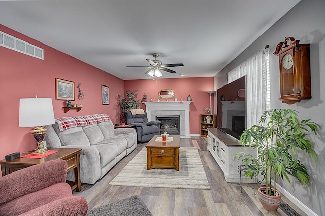 9070 Braxton Dr, Union, KY 41091 - living area with a tiled fireplace, a ceiling fan, and wood finished floors
