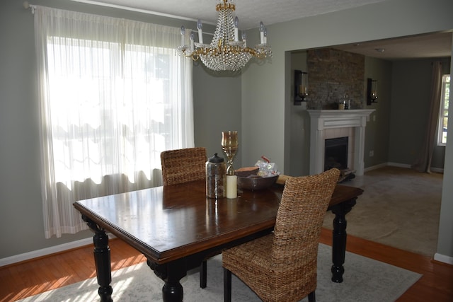 6596 Elgin Ct, Burlington, KY 41005 - dining area with a chandelier, wood finished floors, and a tile fireplace