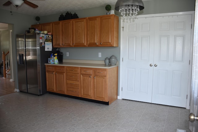 6596 Elgin Ct, Burlington, KY 41005 - kitchen featuring stainless steel fridge with ice dispenser, a ceiling fan, light countertops, brown cabinets, and a chandelier