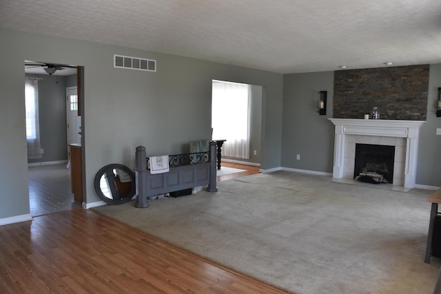 6596 Elgin Ct, Burlington, KY 41005 - living room with a textured ceiling, healthy amount of natural light, a ceiling fan, a tile fireplace, and wood finished floors