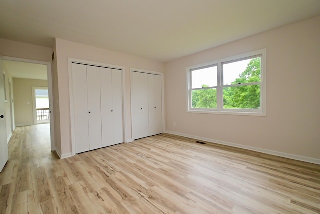 680 Manor Dr, Taylor Mill, KY 41015 - unfurnished bedroom featuring multiple closets and light wood-style floors