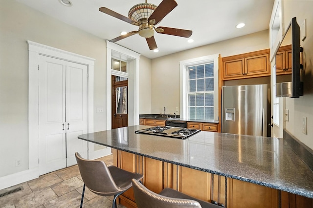 234 Walnut St, Bellevue, KY 41073 - kitchen featuring stainless steel fridge, a peninsula, a ceiling fan, brown cabinetry, and gas stovetop