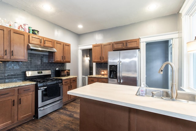 332 W 21st St, Covington, KY 41014 - kitchen with stainless steel appliances, under cabinet range hood, dark wood-style floors, light countertops, and decorative backsplash