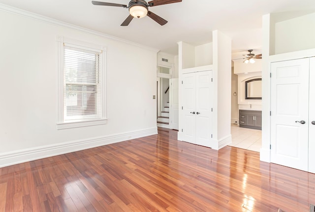 416 E 8th St, Newport, KY 41071 - empty room featuring a ceiling fan, light wood finished floors, crown molding, and stairs