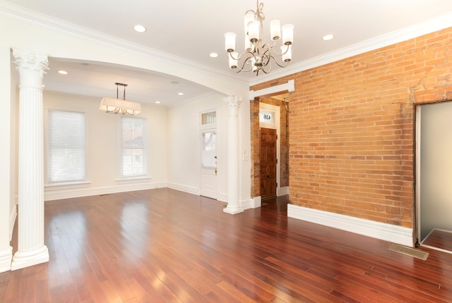 416 E 8th St, Newport, KY 41071 - unfurnished dining area featuring brick wall, decorative columns, wood-type flooring, a chandelier, and arched walkways