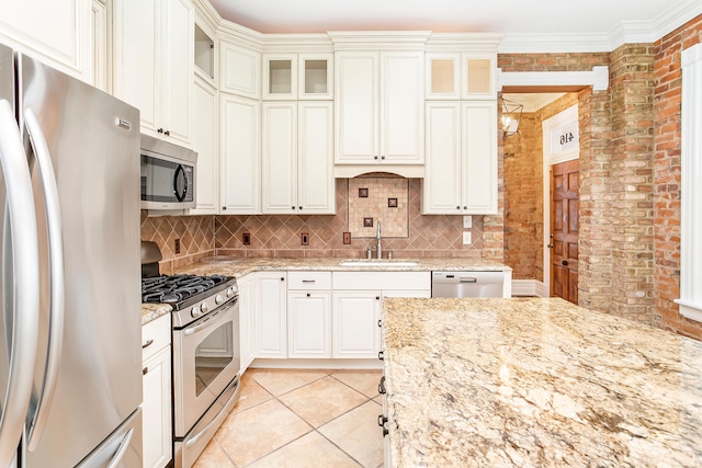 416 E 8th St, Newport, KY 41071 - kitchen featuring stainless steel appliances, brick wall, backsplash, light stone countertops, and light tile patterned floors