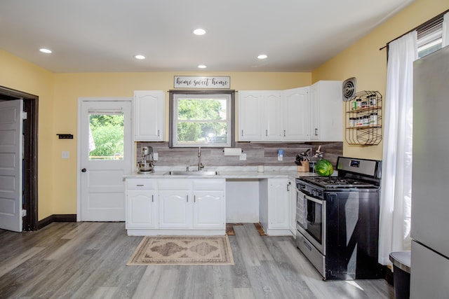 15 21st St, Newport, KY 41071 - kitchen with stainless steel gas stove, white cabinets, light countertops, light wood-style flooring, and recessed lighting
