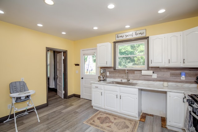 15 21st St, Newport, KY 41071 - kitchen with white cabinetry, decorative backsplash, light wood finished floors, recessed lighting, and gas range