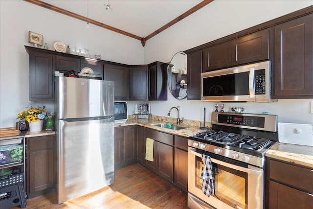 411 E 10th St, Newport, KY 41071 - kitchen featuring appliances with stainless steel finishes, ornamental molding, light stone counters, dark brown cabinets, and light wood finished floors