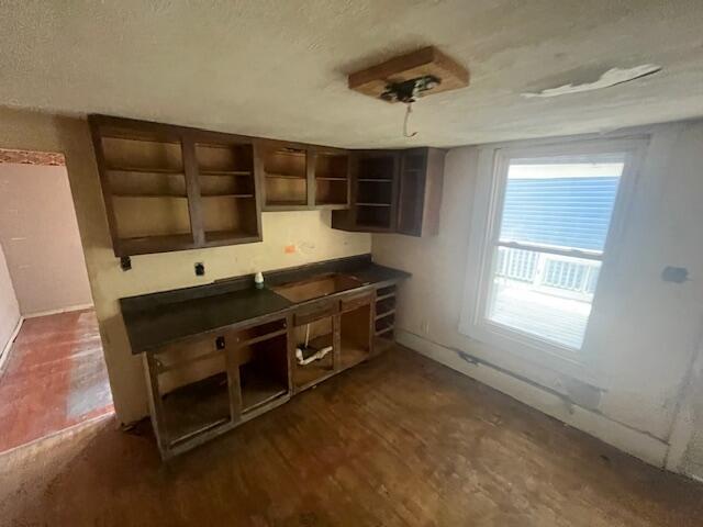 1130 Ann St, Newport, KY 41071 - kitchen with open shelves, dark countertops, a textured ceiling, and dark wood-type flooring
