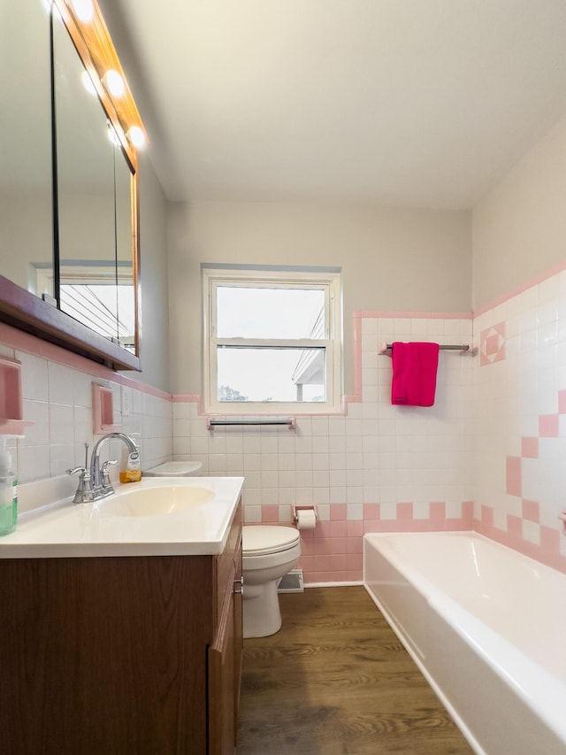 94 Mayo Cir, Newport, KY 41071 - bathroom featuring tile walls, a garden tub, vanity, wood finished floors, and a wainscoted wall