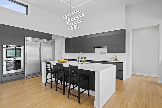 5090 Bella Vista Dr, Cold Spring, KY 41076 - kitchen featuring stainless steel appliances, modern cabinets, dark cabinets, a kitchen bar, and light countertops