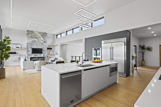 5090 Bella Vista Dr, Cold Spring, KY 41076 - kitchen featuring built in appliances, modern cabinets, an island with sink, light countertops, and a towering ceiling
