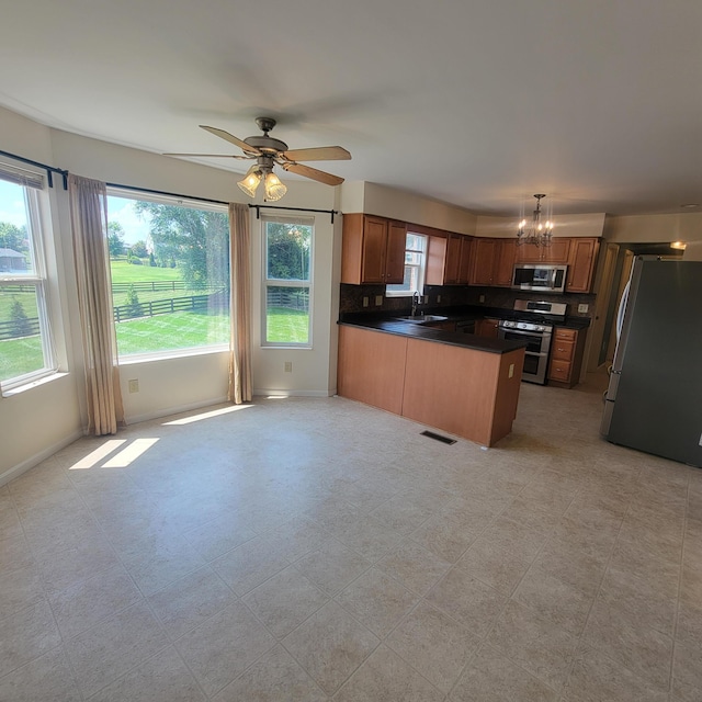4467 Hackberry Ct, Burlington, KY 41005 - kitchen featuring appliances with stainless steel finishes, dark countertops, a peninsula, a ceiling fan, and a chandelier