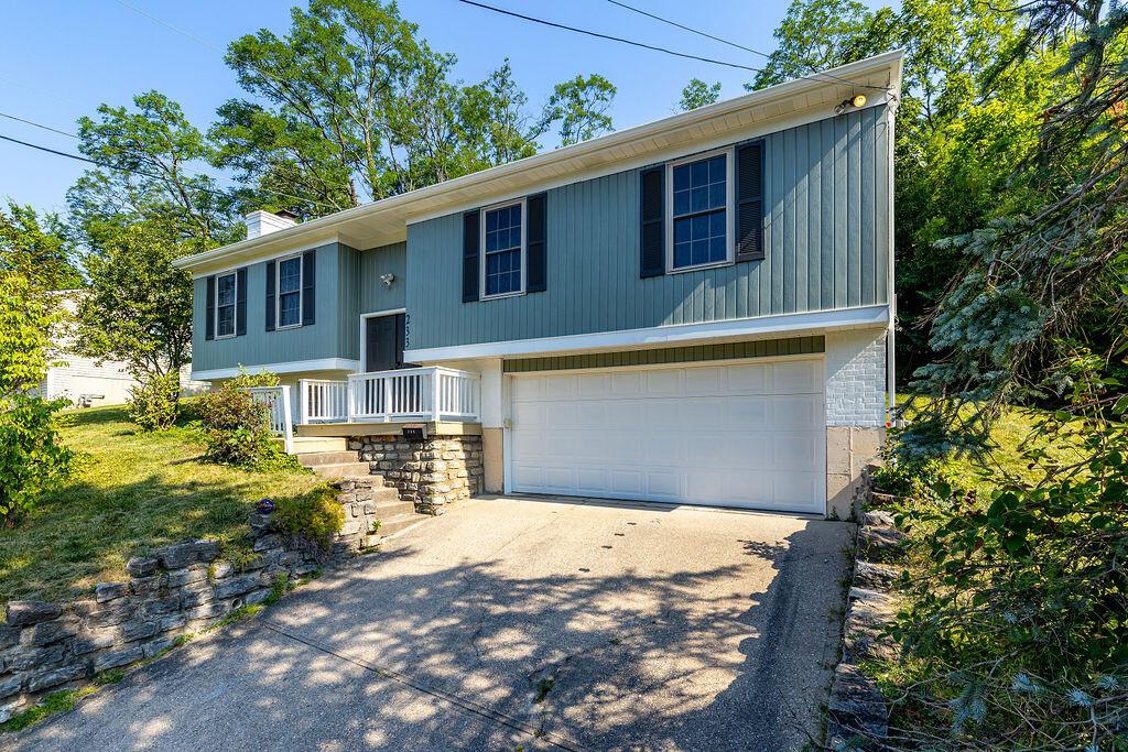 233 Bluegrass Ave, Newport, KY 41071 - raised ranch featuring an attached garage, asphalt driveway, and a chimney