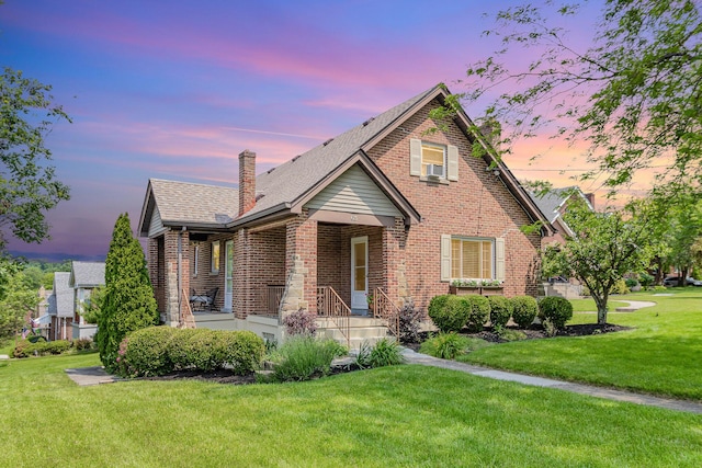 65 W Crittenden Ave, Fort Wright, KY 41011 - view of front of house with brick siding, a front yard, a chimney, covered porch, and cooling unit