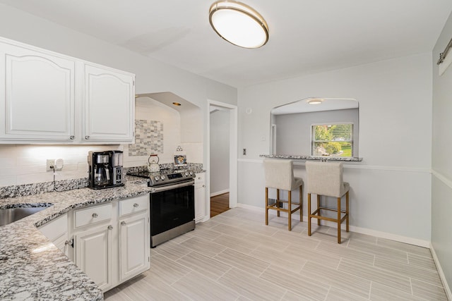 65 W Crittenden Ave, Fort Wright, KY 41011 - kitchen featuring electric range, decorative backsplash, white cabinetry, and light stone counters