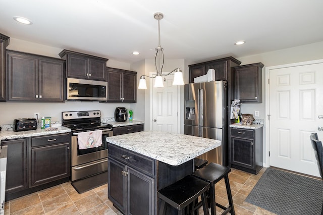 1353 Dominion Trl, Hebron, KY 41048 - kitchen with stainless steel appliances, a breakfast bar area, pendant lighting, a center island, and dark brown cabinets
