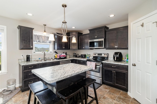 1353 Dominion Trl, Hebron, KY 41048 - kitchen featuring appliances with stainless steel finishes, a kitchen breakfast bar, a kitchen island, decorative light fixtures, and recessed lighting