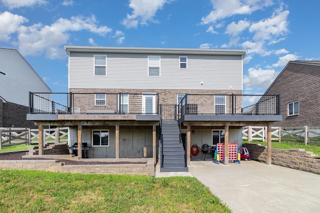1353 Dominion Trl, Hebron, KY 41048 - rear view of house with stairs, a wooden deck, brick siding, and a patio