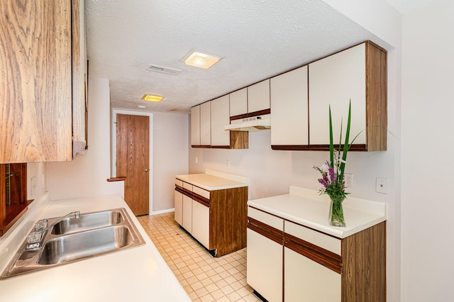2646 Bryan Station Ln, Crestview Hills, KY 41017 - kitchen featuring under cabinet range hood, a textured ceiling, white cabinets, light countertops, and light tile patterned floors