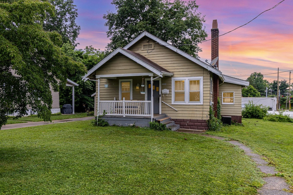 3304 Elizabeth St, Erlanger, KY 41018 - bungalow-style house featuring a porch, a front yard, and a chimney