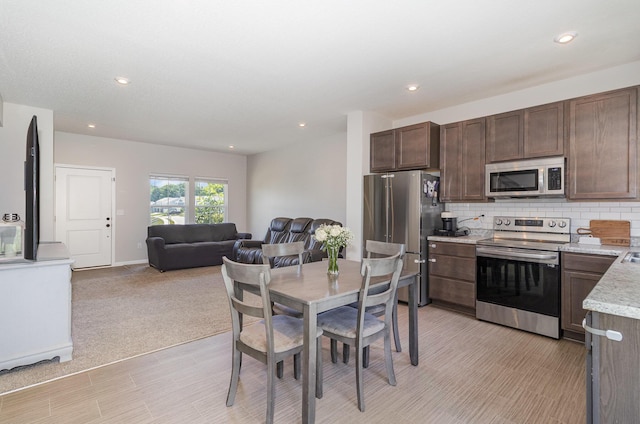 928 Darlington Creek Dr, Alexandria, KY 41001 - kitchen featuring stainless steel appliances, open floor plan, tasteful backsplash, dark brown cabinets, and recessed lighting