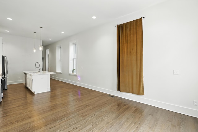 310 W Robbins St, Covington, KY 41011 - kitchen with light countertops, dark wood-style floors, recessed lighting, a kitchen island with sink, and white cabinetry