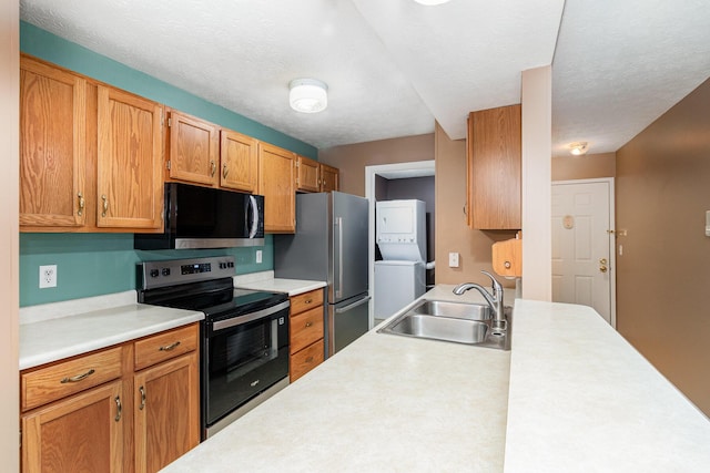 37 Rio Grande Cir Unit 5, Florence, KY 41042 - kitchen with appliances with stainless steel finishes, stacked washer / drying machine, light countertops, and brown cabinetry