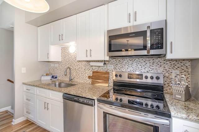 30 Valeside Dr, Covington, KY 41017 - kitchen with stainless steel appliances, white cabinetry, backsplash, light stone counters, and light wood-type flooring